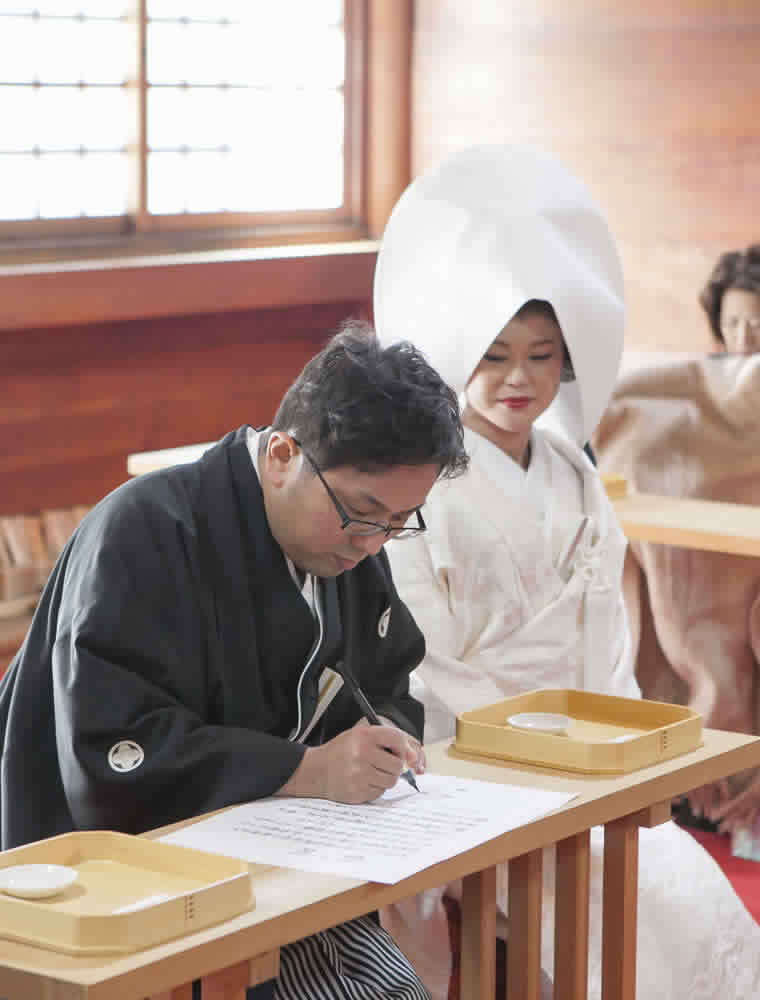 那古野神社の本殿で結婚を誓うサインをする新郎