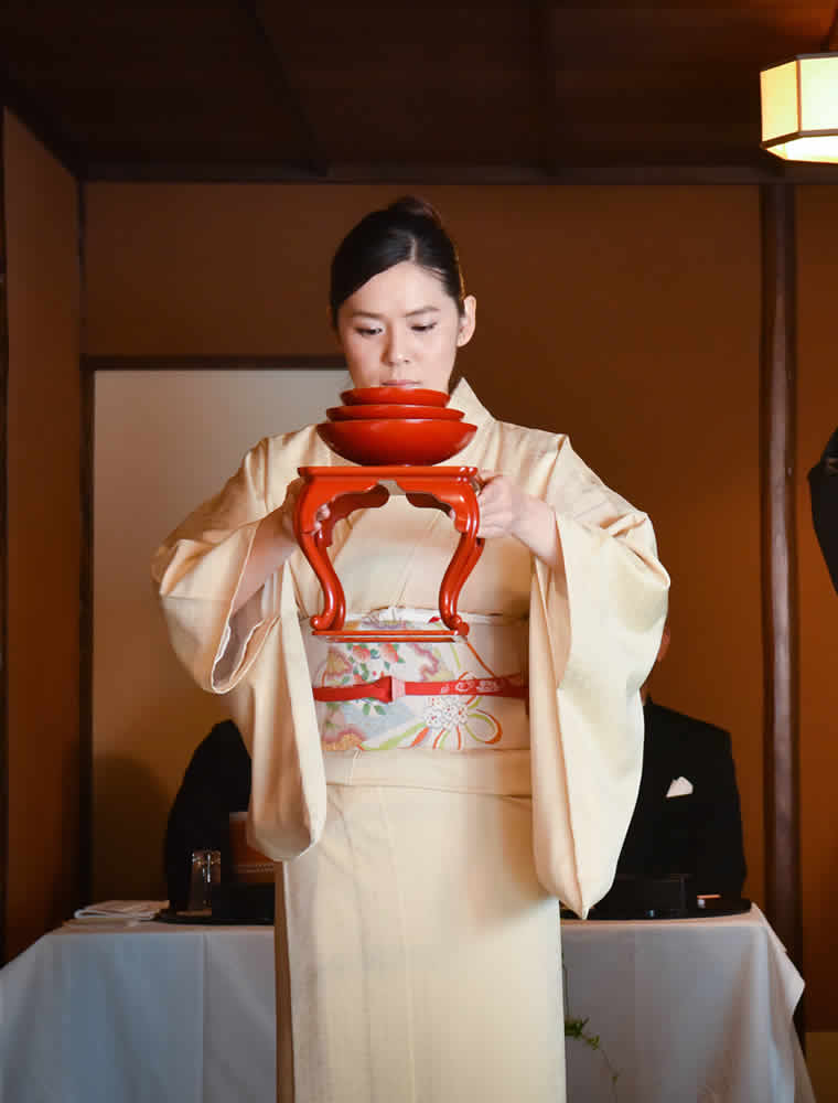 三三九度に盃を新郎新婦のもとへ運びます