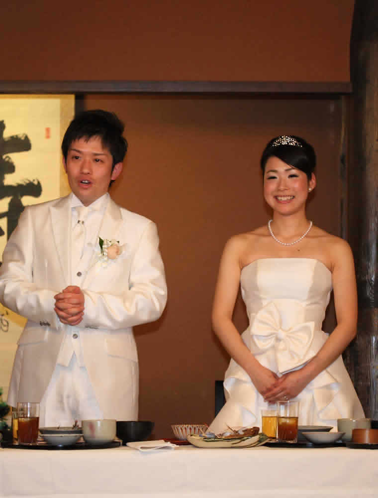 料亭でウェディングドレスと白いタキシードにお色直しをした新郎新婦